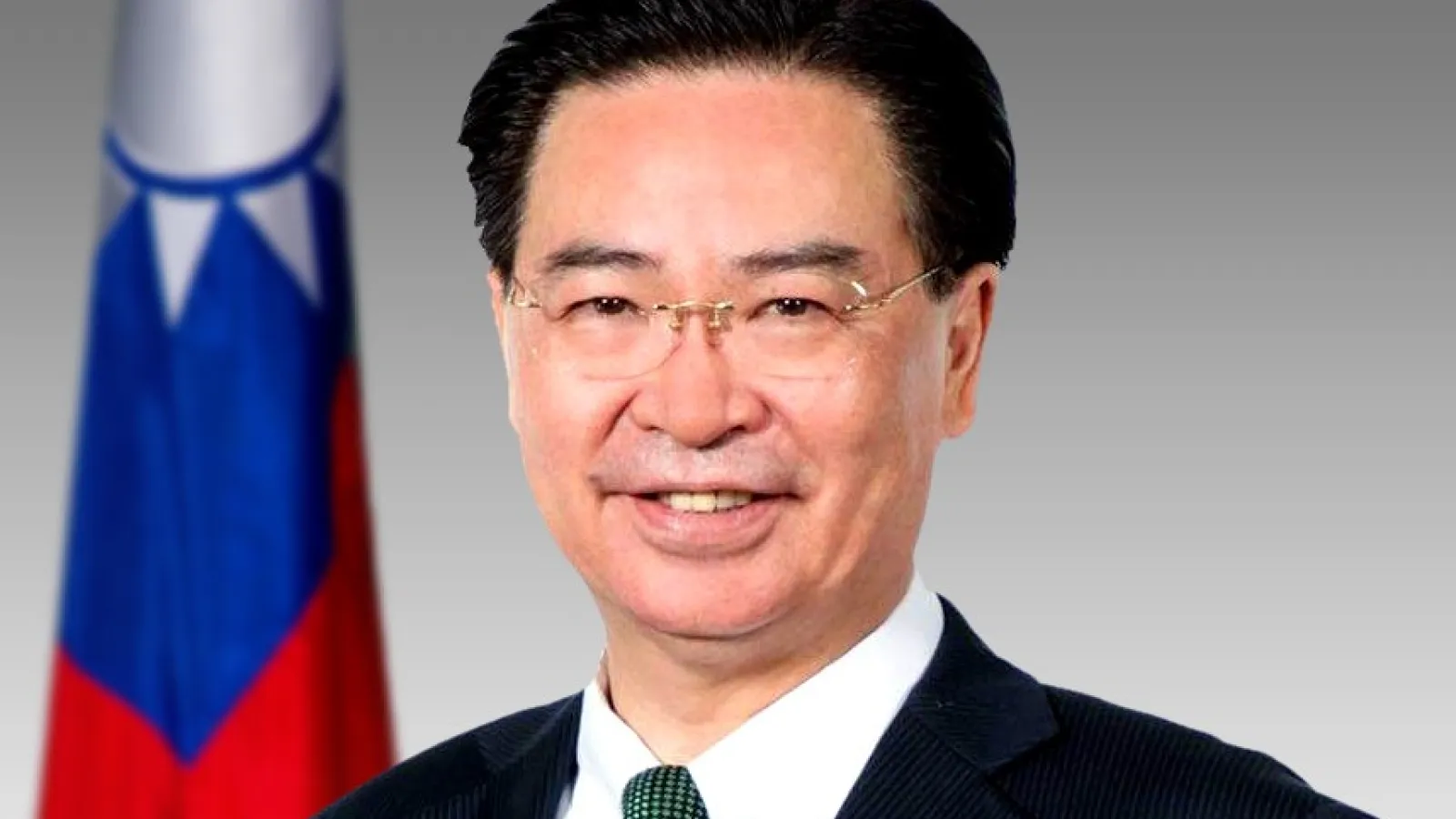 Joseph Wu Headshot in front of Taiwan flag 