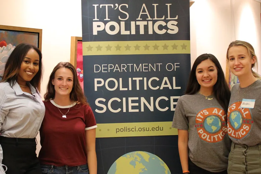 Students standing in front of a department banner
