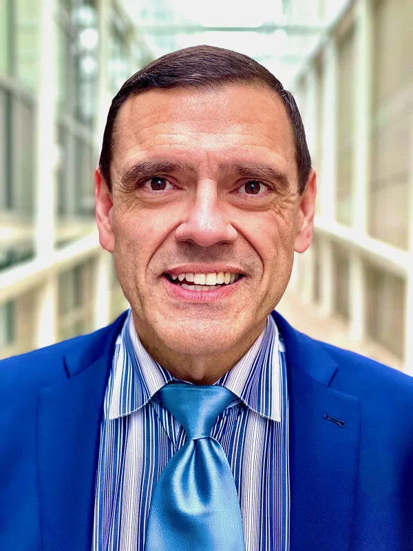 Michael Neblo headshot- white man with brown hair wearing blue suit, with blue tie and striped blue shirt